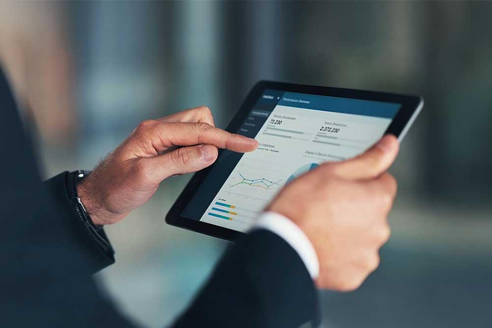 Närbild på affärsmans händer som håller surfplatta med finansiella diagram och dataanalys